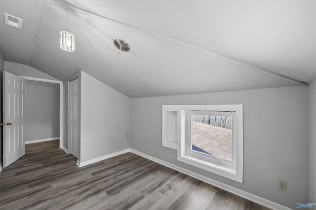 bonus room featuring lofted ceiling, visible vents, baseboards, and wood finished floors