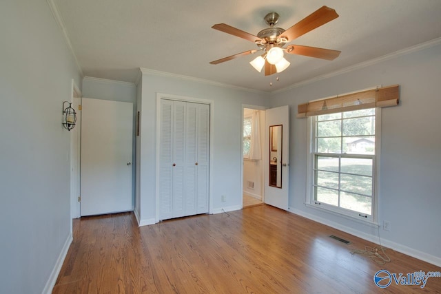 unfurnished bedroom featuring light wood-type flooring, visible vents, ornamental molding, and baseboards