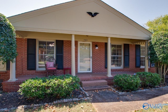 view of front of house with a porch and brick siding