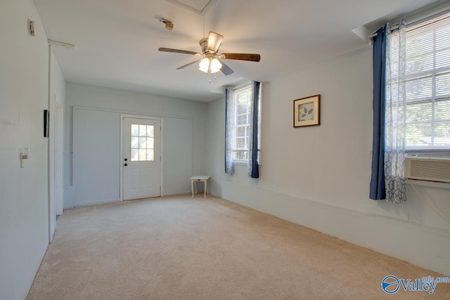 entryway with light carpet, cooling unit, and a ceiling fan