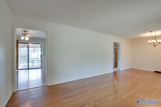 spare room with baseboards, crown molding, light wood finished floors, and ceiling fan with notable chandelier