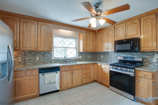 kitchen featuring decorative backsplash, appliances with stainless steel finishes, brown cabinets, light stone counters, and a sink