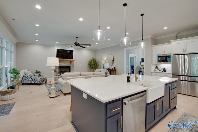 8076 Goose Ridge Dr, Owens Cross Roads, AL 35763 - kitchen with stainless steel appliances, a sink, white cabinets, a ceiling fan, and light wood-type flooring