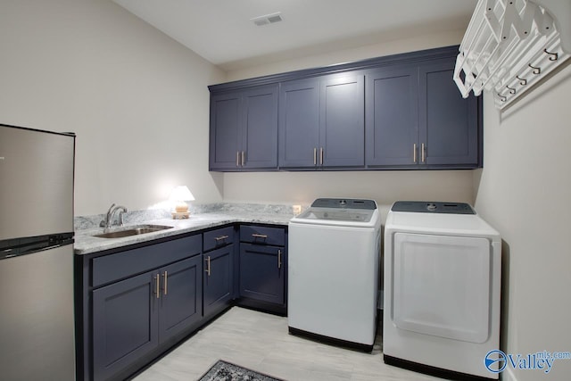 8076 Goose Ridge Dr, Owens Cross Roads, AL 35763 - laundry room with cabinet space, washer and dryer, and light wood-style floors