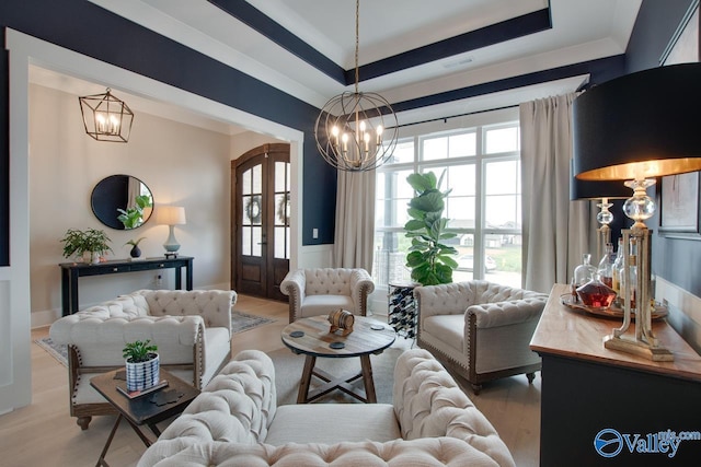8076 Goose Ridge Dr, Owens Cross Roads, AL 35763 - living area featuring a chandelier, light wood finished floors, a raised ceiling, wainscoting, and french doors