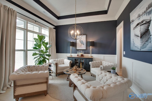 8076 Goose Ridge Dr, Owens Cross Roads, AL 35763 - living area with a chandelier, a wainscoted wall, a tray ceiling, and a decorative wall