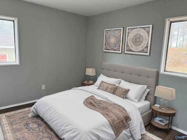 bedroom with multiple windows and hardwood / wood-style flooring