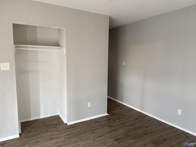 unfurnished bedroom featuring dark hardwood / wood-style flooring and a closet