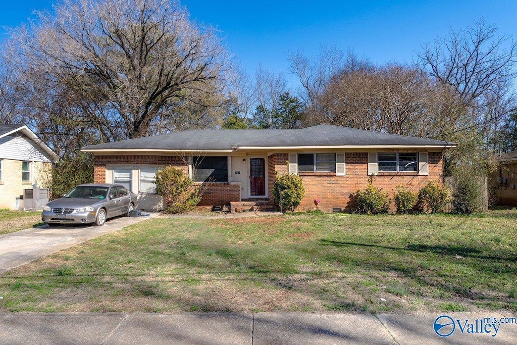 single story home featuring concrete driveway, brick siding, and a front yard