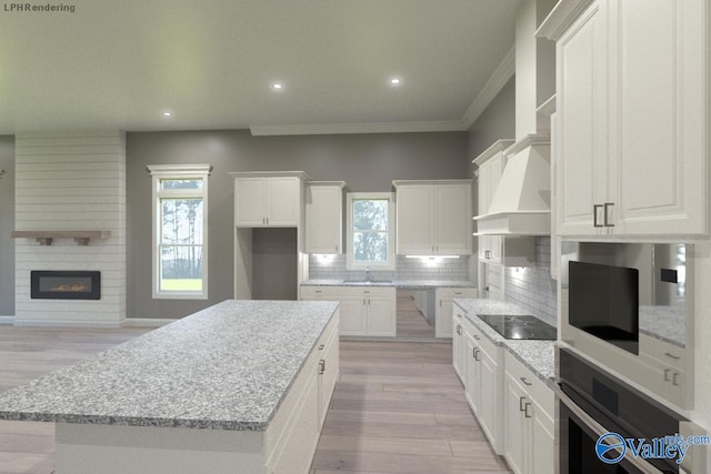 kitchen with wall oven, light stone countertops, white cabinets, a kitchen island, and decorative backsplash