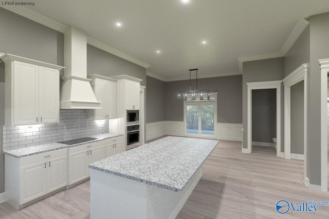 kitchen featuring light stone countertops, stainless steel oven, and white cabinets