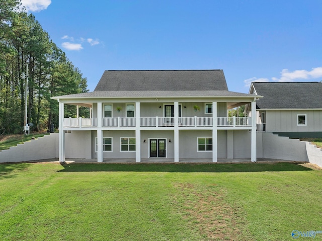 rear view of property featuring a lawn and a balcony