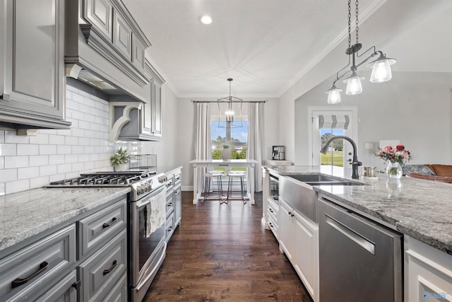 kitchen featuring backsplash, gray cabinetry, appliances with stainless steel finishes, ornamental molding, and premium range hood