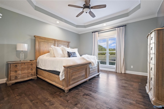bedroom featuring dark wood finished floors, baseboards, a ceiling fan, crown molding, and a raised ceiling