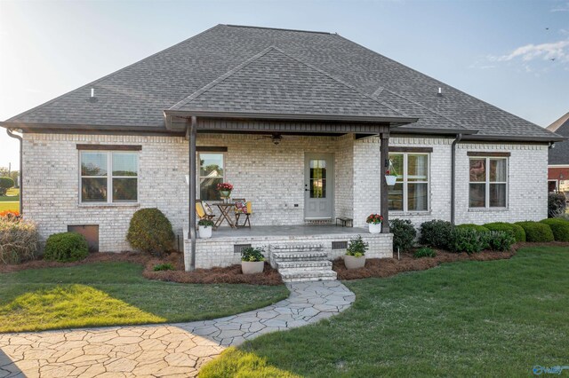 view of front of home featuring a front lawn, roof with shingles, a porch, and ceiling fan