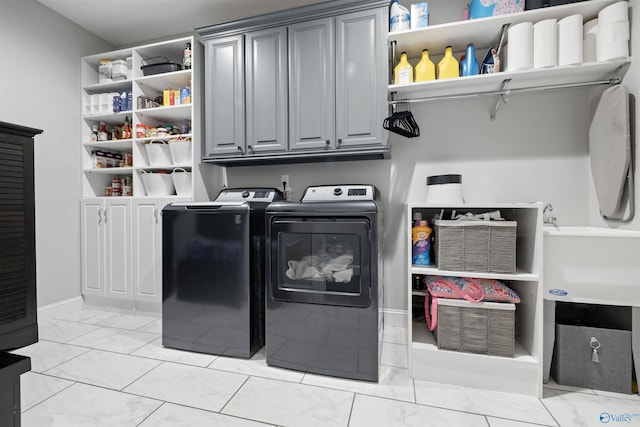 laundry room with washing machine and dryer, cabinet space, and marble finish floor