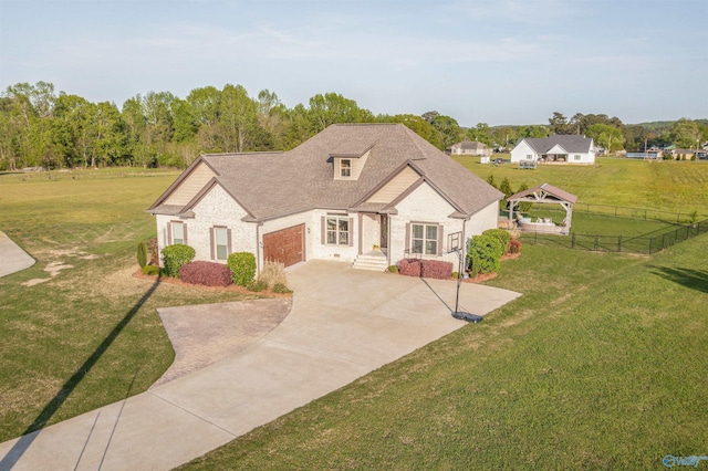 view of front of home featuring a gazebo, a front lawn, driveway, an attached garage, and fence