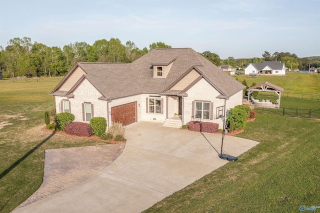 view of front of house featuring a front yard, an attached garage, concrete driveway, and fence
