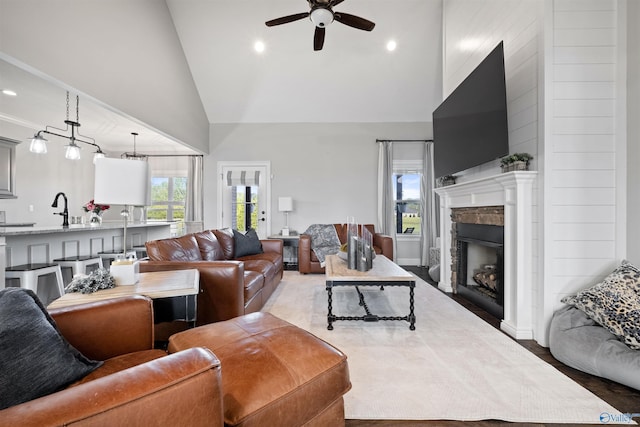 living area featuring recessed lighting, a stone fireplace, wood finished floors, high vaulted ceiling, and ceiling fan