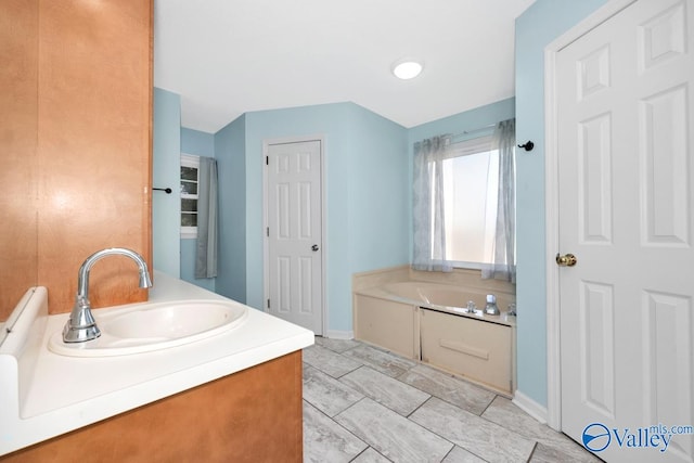 bathroom with tile patterned flooring, a bathing tub, and vanity