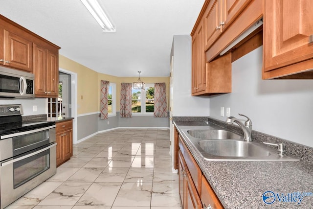 kitchen featuring light tile patterned flooring, sink, stainless steel appliances, and pendant lighting