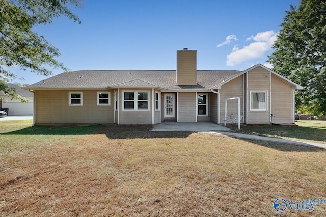 rear view of property featuring a lawn and a patio area