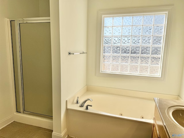 full bathroom featuring a jetted tub, a stall shower, tile patterned flooring, and vanity