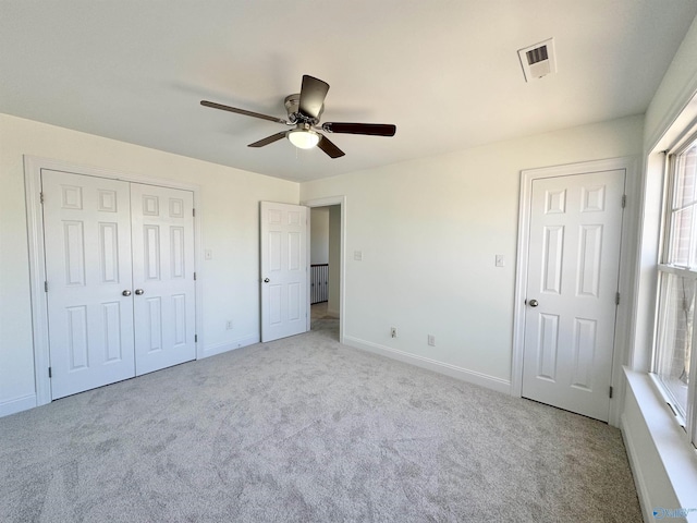 unfurnished bedroom with carpet, a closet, visible vents, ceiling fan, and baseboards