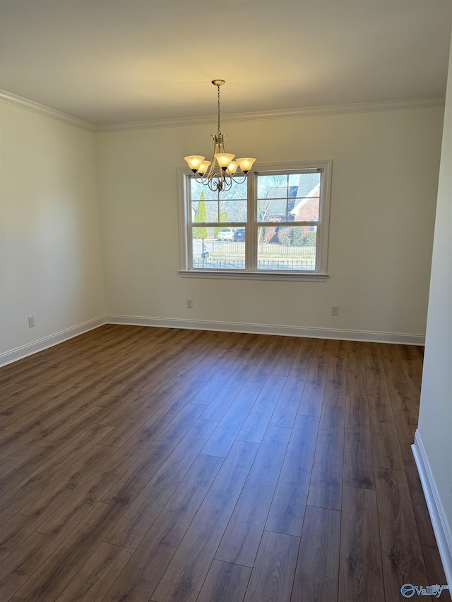 unfurnished room featuring dark wood-style floors, crown molding, baseboards, and a notable chandelier