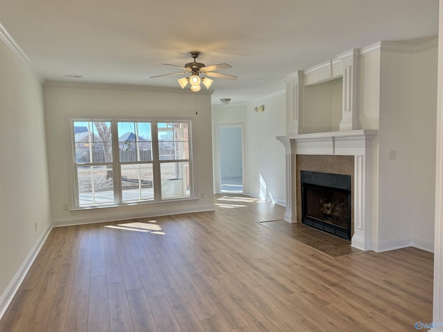 unfurnished living room with a fireplace, wood finished floors, a ceiling fan, baseboards, and ornamental molding