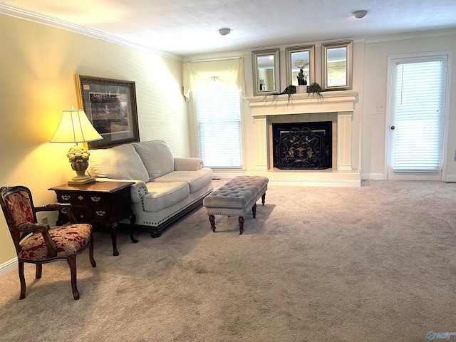 carpeted living room with baseboards, ornamental molding, and a fireplace with raised hearth