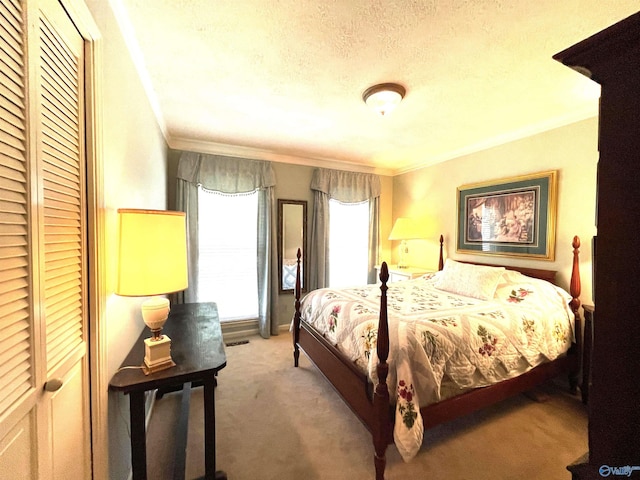 bedroom featuring a textured ceiling, ornamental molding, a closet, and light colored carpet