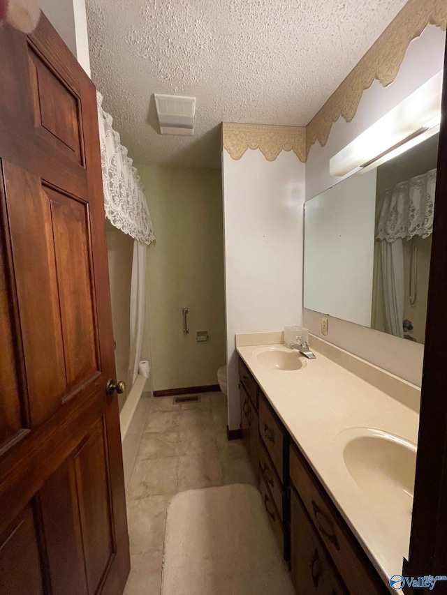 full bathroom with vanity, tile patterned floors, a textured ceiling, toilet, and shower / bath combo