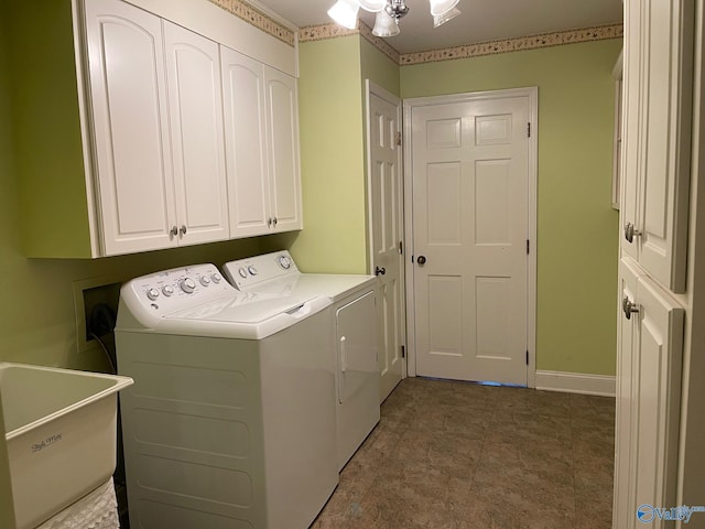 washroom featuring washer and dryer, cabinet space, a sink, and baseboards