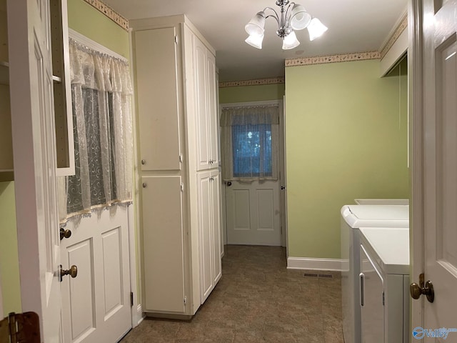 clothes washing area with visible vents, cabinet space, washing machine and dryer, a chandelier, and baseboards