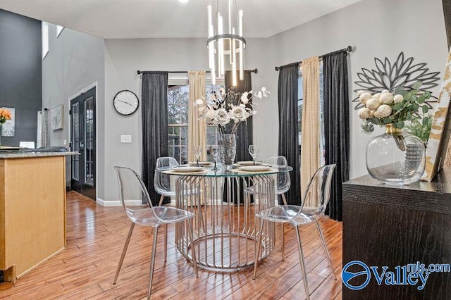 dining space featuring a notable chandelier and light wood-type flooring