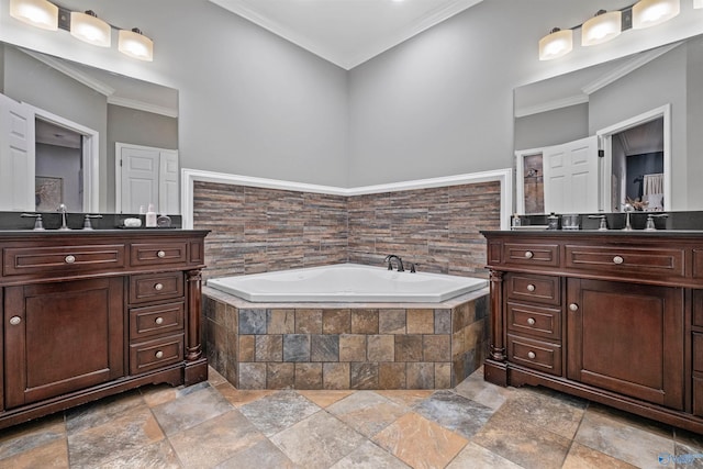 bathroom with vanity, crown molding, and tiled tub