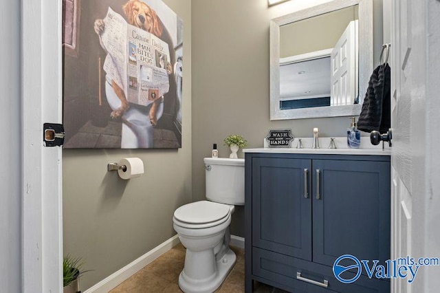 bathroom with tile patterned flooring, vanity, and toilet