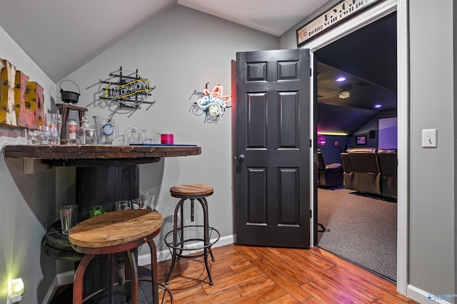 bar with hardwood / wood-style floors and lofted ceiling