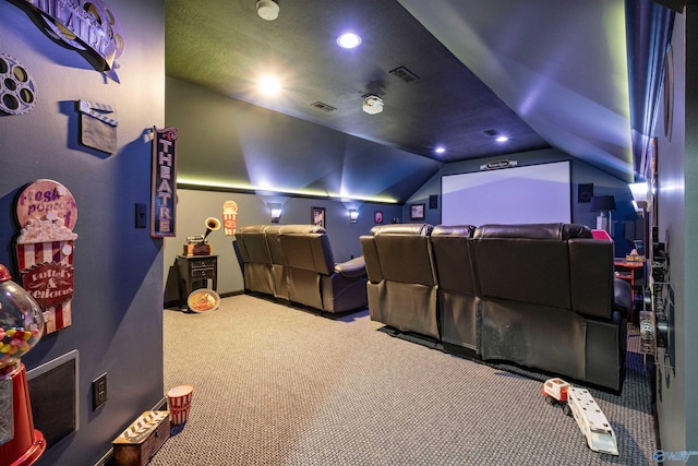 carpeted cinema room with vaulted ceiling