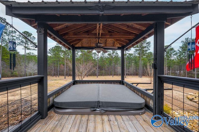 wooden deck featuring ceiling fan and a covered hot tub