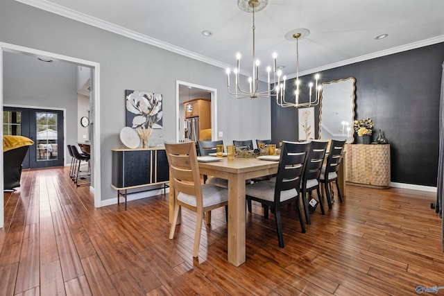 dining area with a notable chandelier, wood-type flooring, ornamental molding, and french doors