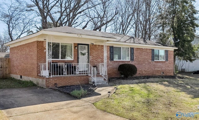 view of front facade featuring crawl space, covered porch, fence, and brick siding