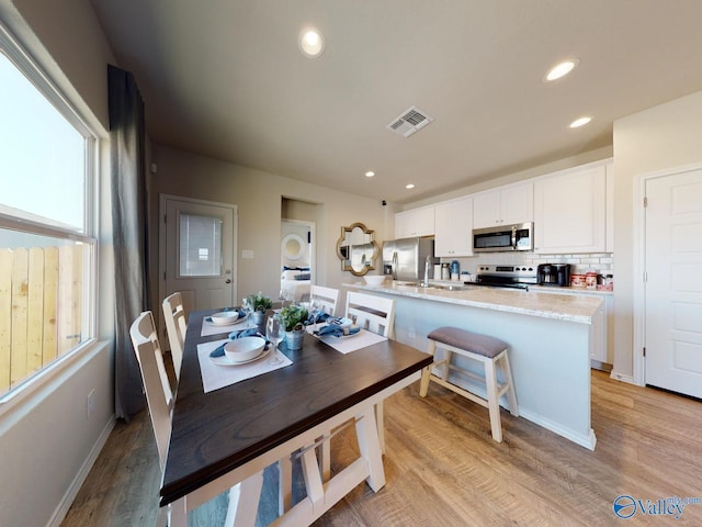 dining space featuring sink and light wood-type flooring