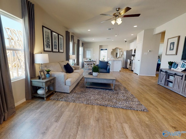 living room with light hardwood / wood-style floors and ceiling fan