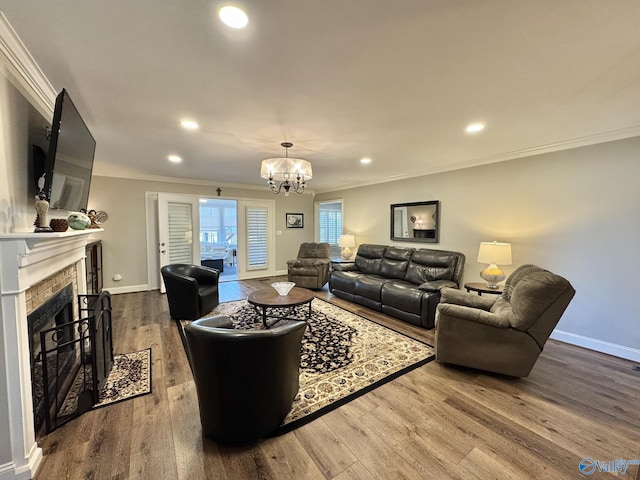 living room with an inviting chandelier, hardwood / wood-style flooring, and crown molding