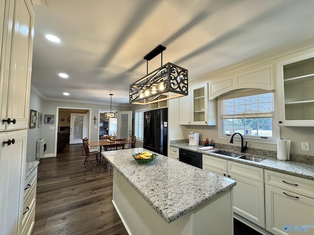 kitchen with a center island, sink, light stone counters, and black appliances