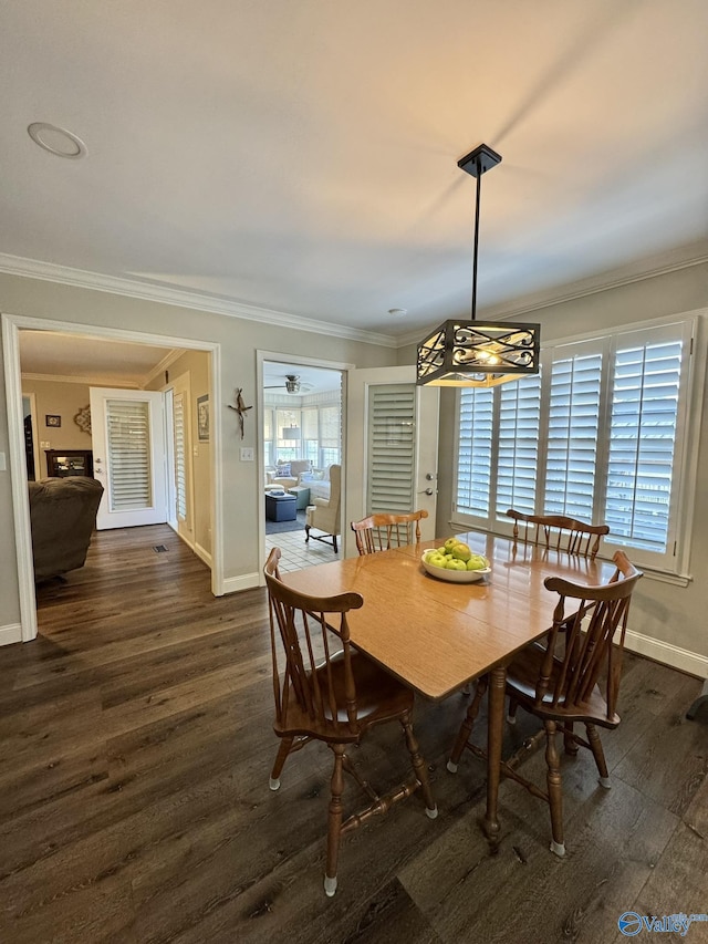 dining space with crown molding and dark hardwood / wood-style floors