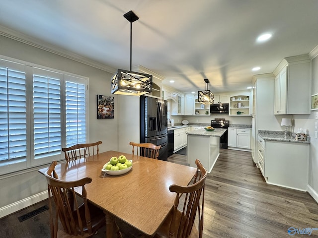 dining room featuring sink, ornamental molding, and dark wood-type flooring