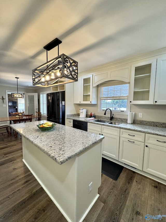 kitchen with black appliances, decorative light fixtures, a kitchen island, sink, and dark hardwood / wood-style floors